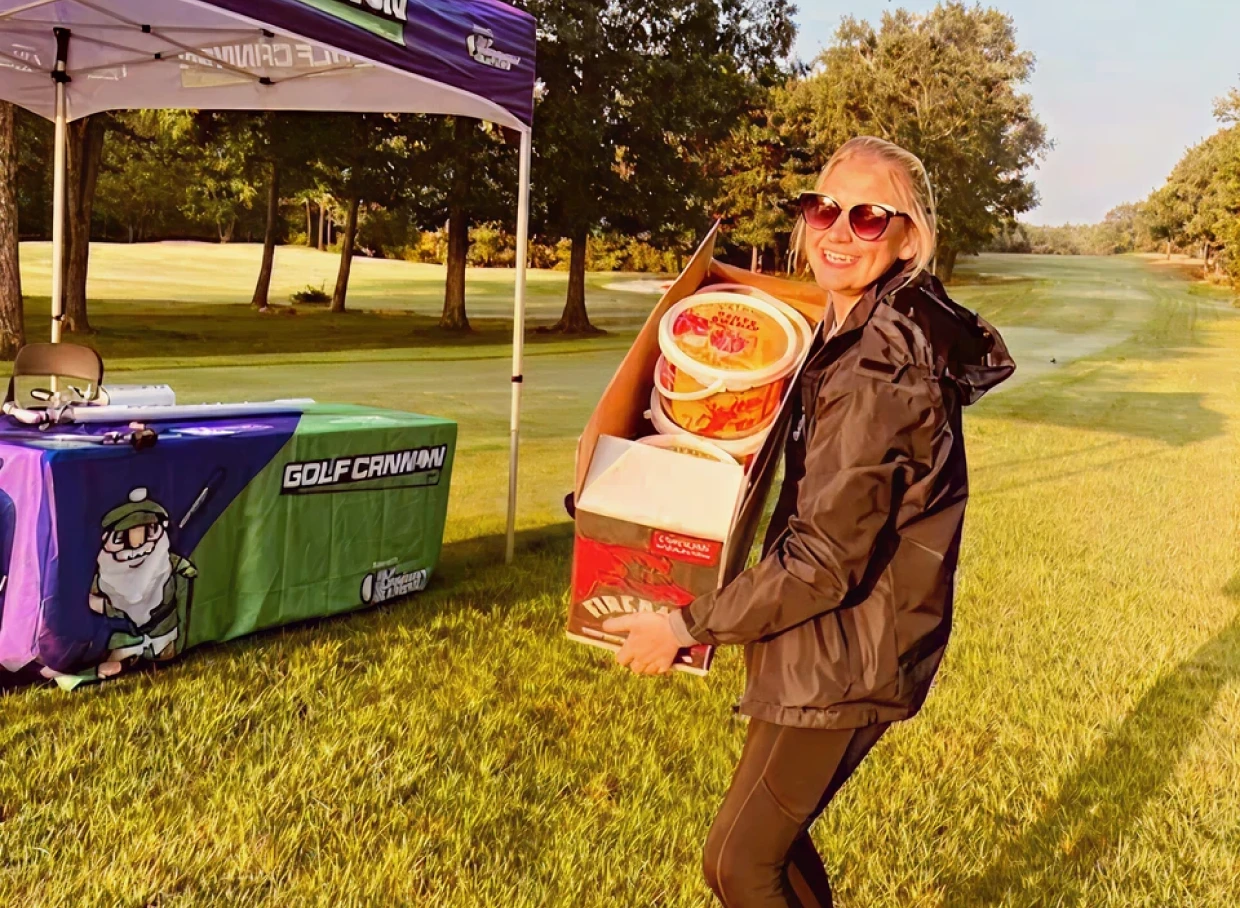 Woman carrying boxes at golf event
